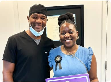 Signature Smiles | Dentist and happy patient posing together holding a sign