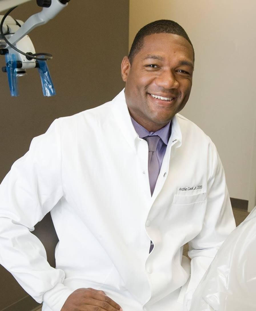 Signature Smiles | Dr. Archie Cook Jr. DDS smiling seated in dental treatment room