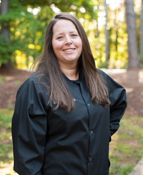 Signature Smiles | Dental team member smiling outdoors wearing black uniform jacket